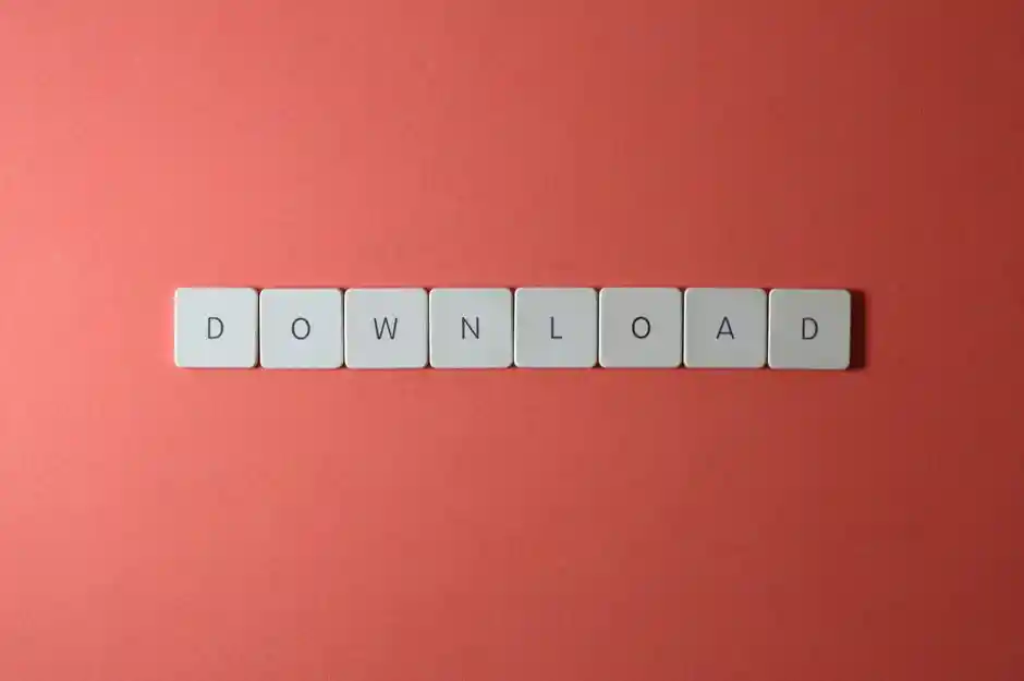 Minimalist photo of keyboard tiles spelling 'DOWNLOAD' on a red background.